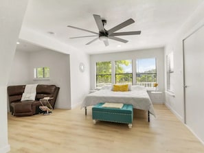 Master bedroom with king size bed, Roku TV, plenty of light and sitting area