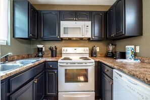 Step into my chic kitchen where black cabinets meet beautiful granite countertops, creating a perfect blend of style and functionality. Every corner of this space is designed to impress.