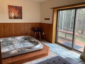 Indoor Spa next to fireplace (wood burning) and outdoor patio.