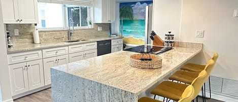This newly upgraded galley kitchen has granite countertops and seating 