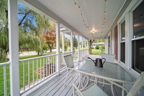 The front porch spans the width of the home. There is a dining set that seats 4, and a very spacious side yard for games.