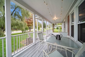 The front porch spans the width of the home. There is a dining set that seats 4, and a very spacious side yard for games.