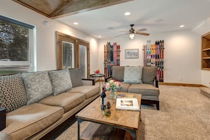 Living Room with cozy gas fireplace, Smart TV, plush furnishings, vaulted ceiling, and patio access.