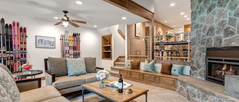 Living Room with cozy gas fireplace, Smart TV, plush furnishings, vaulted ceiling, and patio access.