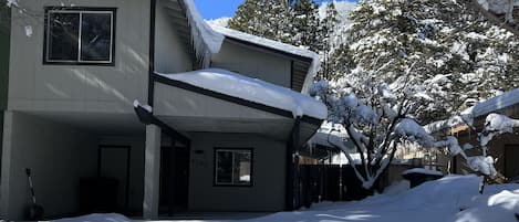 Front of the house covered in snow with Mt Elden in the background. 