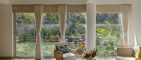 Living room with frontal garden and forest views.