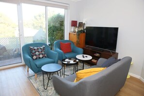Lounge room, large TV (with soundbar) with Netflix + chrome-cast, plus a selection of books and games.