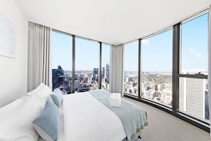 The master bedroom with a queen-sized bed, plush pillows and city views..