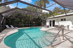 [Backyard] Screened-in heated pool with lounge area.
