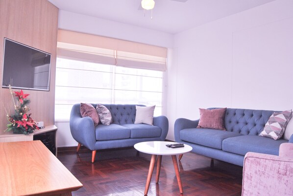 Living room with a smart TV/cable, two sofas and a circular table