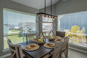 Dine with beach views in this stunning dining room! Surrounded by windows that showcase the Gulf, this inviting space brings the beauty of the coast to every meal. You'll feel like you're right on the beach, making it hard to ever want to leave.