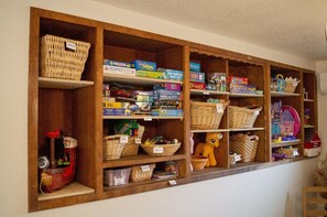 Dining room shelves containing over 100 games, puzzles, toys for kids & adults.