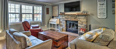 Living Room with smart TV over wood-burning fireplace.
