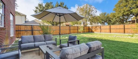 Be sure to take the time to enjoy Texas’ beautiful warm weather on this fully furnished backyard patio set featuring a conversation set, coffee table, and umbrella!