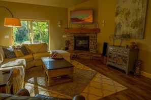 Living room with gas fireplace, flat screen tv, and access to spectacular outdoor patio space.