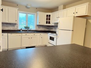 View of the bright and spacious kitchen from dining room entry
