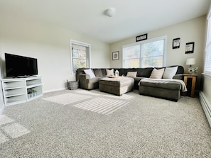 Living room with large sectional sofa and smart tv overlooking the orchard 