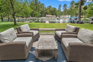 Peaceful Setting: Relax and unwind in a quiet, serene atmosphere by the water with firepit, grassy yard and large deck.