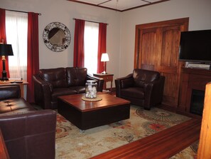 Living room with leather lounging furniture and a smart TV.