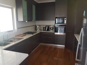 Fully equipped kitchen with coffee machine, steam oven and air fryer.