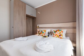 A cozy bedroom with a large bed, soft linens, and wooden accents for a warm and inviting atmosphere.
