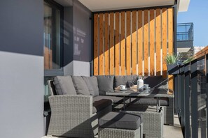 A private balcony with comfortable seating and a partial view of the urban surroundings, perfect for relaxation.
