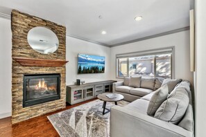 The spacious living room provides sectional seating for all to sprawl out by the fireplace & watch the wall-mounted 64" HDTV.