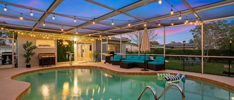 Heated, saltwater pool oasis with relaxing lighting, furniture, and bbq grill.