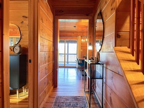 The entryway invites you to explore the beauty of the masterfully crafted log cabin.