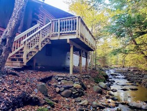 Spacious Deck w/ BBQ and chairs overlooking the brook. Relax and listen to the sounds.