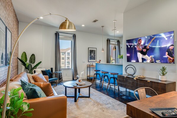 Bright and open living area with designer furnishings and smart TV.