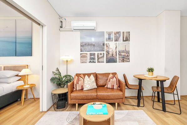 Welcome to your stylish and comfortable urban retreat! Our open-plan living area features a plush leather sofa, chic decor, and ample natural light, perfect for relaxing after a day of exploring.