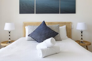 Unwind in this cozy bedroom, featuring a comfortable bed, soft linens, and a touch of natural light.