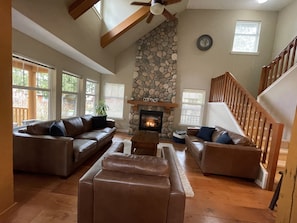 Living room with vaulted ceiling and river rock fireplace. 