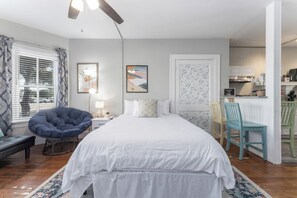 A luminous chamber with a chic, tranquil vibe. Anchored by a Queen-size bed, adorned in crisp linens, accented by vibrant art, and bathed in natural light. Ideal for unwinding in minimalist elegance.