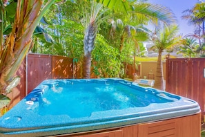 Unwind in the 6 seater hot tub surrounded by palm trees