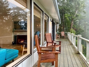 Balcony seating amongst the trees, clouds and water.