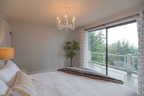 Master bedroom overlooking the deck outside with water views.