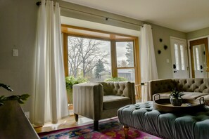 Living area soaked in sunlight from the large bay window