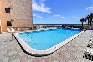 Condo pool with seating and lounge chairs