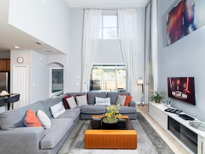 Living room features SmartTV and high ceilings