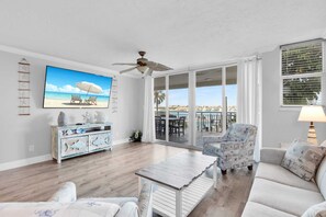 Large living room area with 70" TV and water views