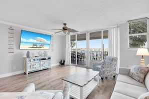 Large living room area with 70" TV and water views