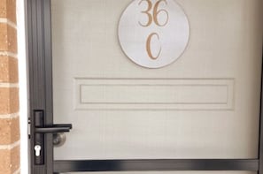 Front door with protective screen and the  house number of '36C'