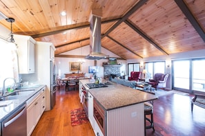 Rustic charm meets modern elegance in open kitchen and living area with fireplace.