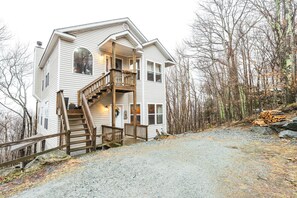 Luxurious two-story haven with balconies, lush woods, and rustic ambiance.