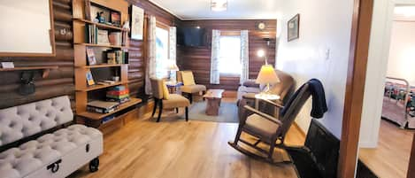 Living room with TV, couch, chairs, rocking chair and fancy bench. 