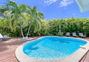 Large swimming pool and deckchair on a wooden deck