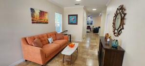 Entrance of the home leads to a living area with comfy sofa bed and fireplace.