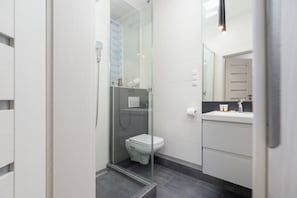 A modern bathroom with a walk-in shower, sleek tiles, and a clean, minimalist design.
